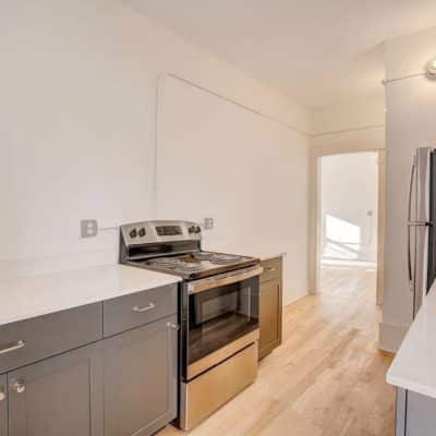 A Kitchen With Stainless Steel Appliances And Wooden Cabinets