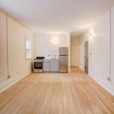 A Large Empty Room With A Hard Wood Floor