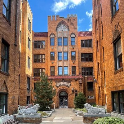 A Large Stone Statue In Front Of A Brick Building