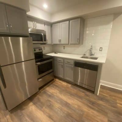 A Large Kitchen With Stainless Steel Appliances And Wooden Cabinets
