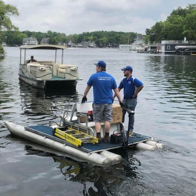 A Group Of People In A Small Boat In A Body Of Water