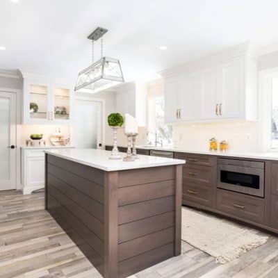 A Modern Kitchen With Stainless Steel Appliances And Wooden Cabinets